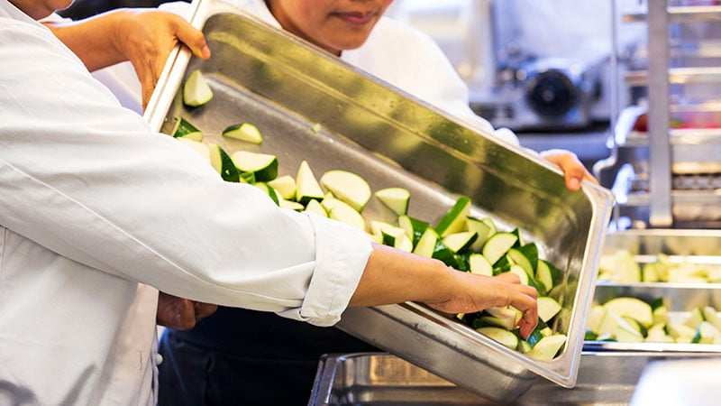 Kock lagar mat med grönsaker.